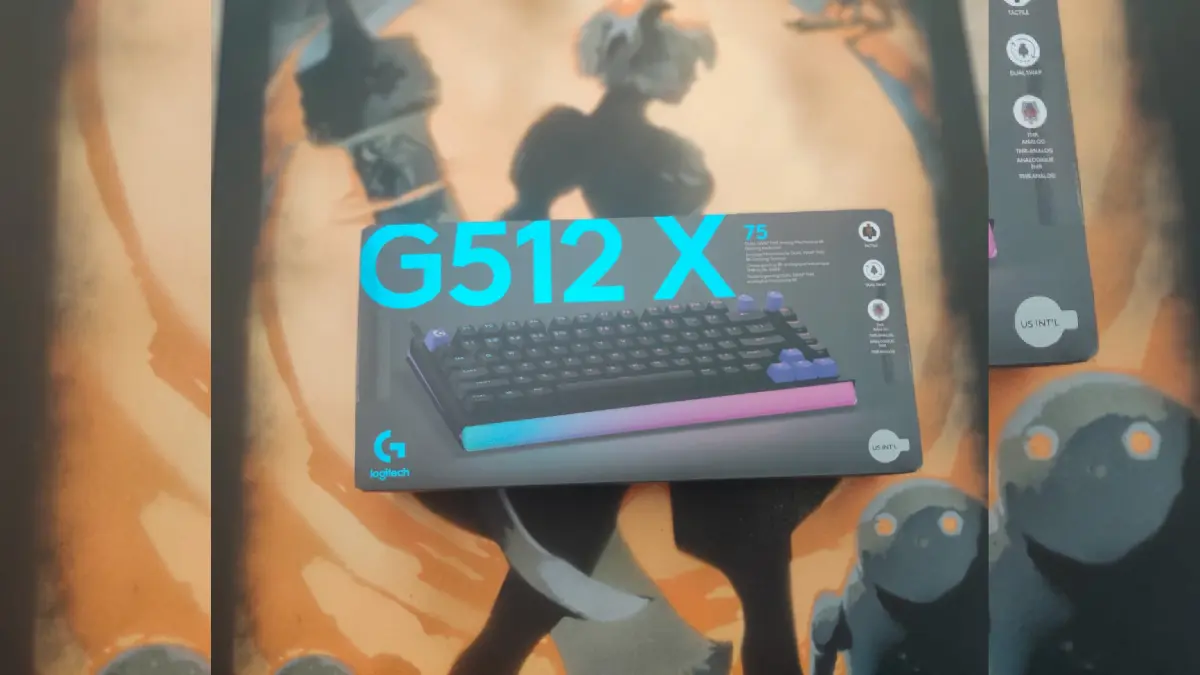 Cutia tastaturii gaming Logitech G512 X 75 fotografiata langa un tablou cu design artistic in nuante de portocaliu si gri