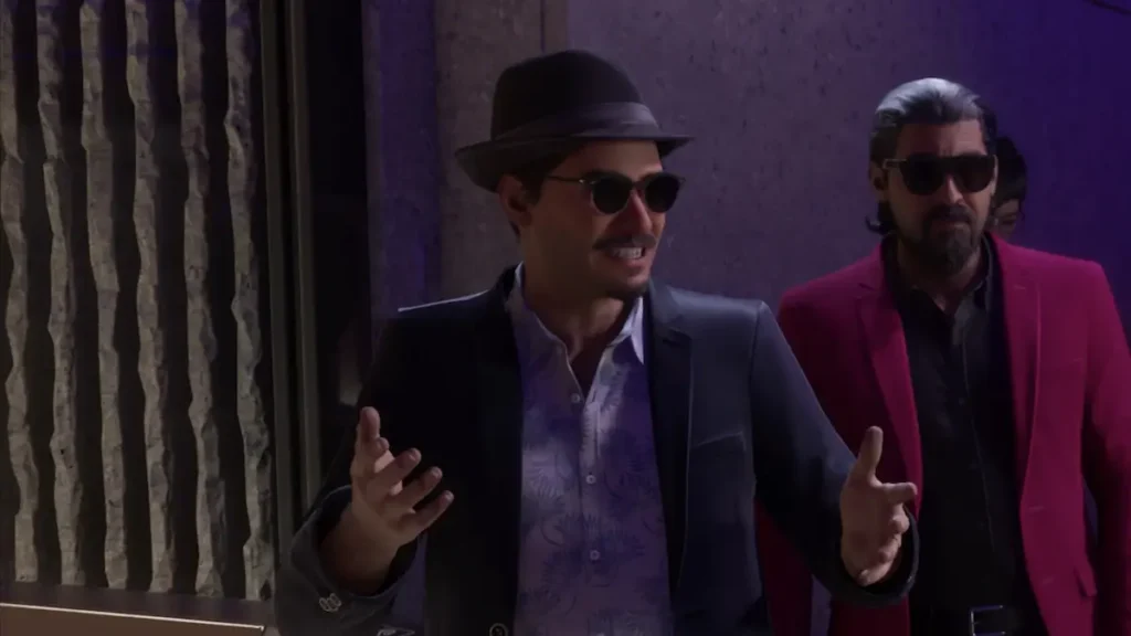 Andres de Leon, cu pălărie fedora și ochelari de soare, gesticulează în timp ce vorbește, captură din GTA 6